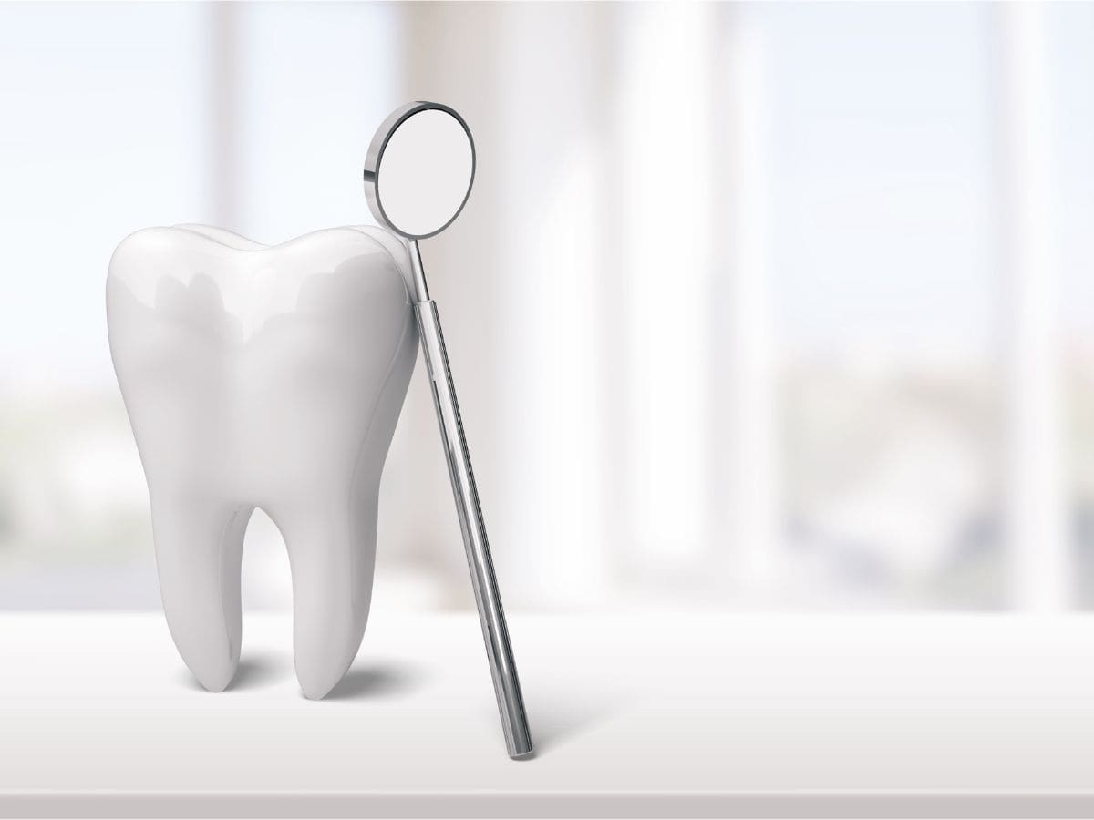 Tooth With Dental Mirror Tool Next To It - City Creek Dental